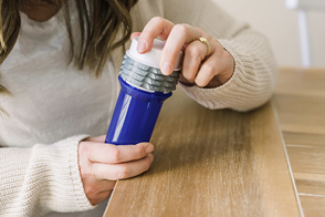 Set of hands is closing a locking pill bottle.