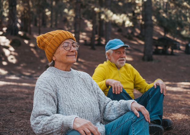 Older couple sitting in the woods.