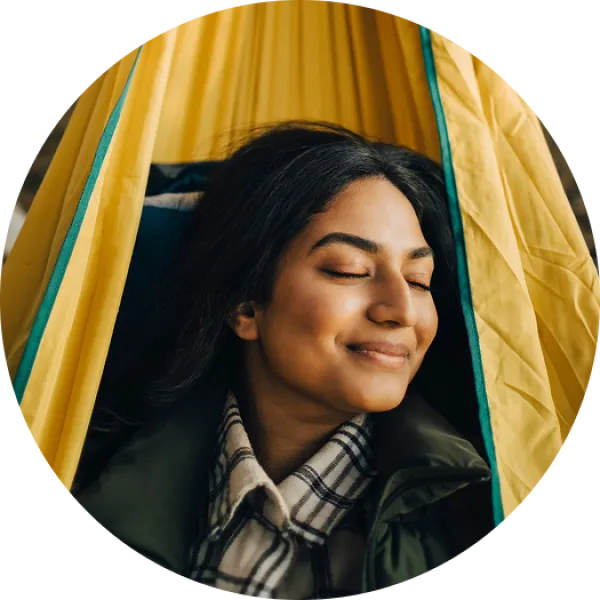 woman with closed eyes rest in yellow hammock, circle frame.